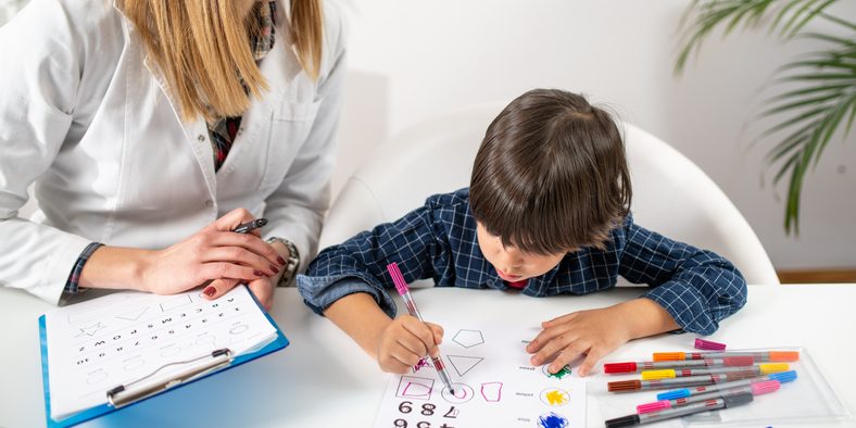 child receiving help for trouble with writing